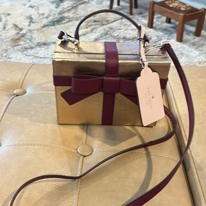 Kate, spade gold bag wrapped with a maroon bow never used